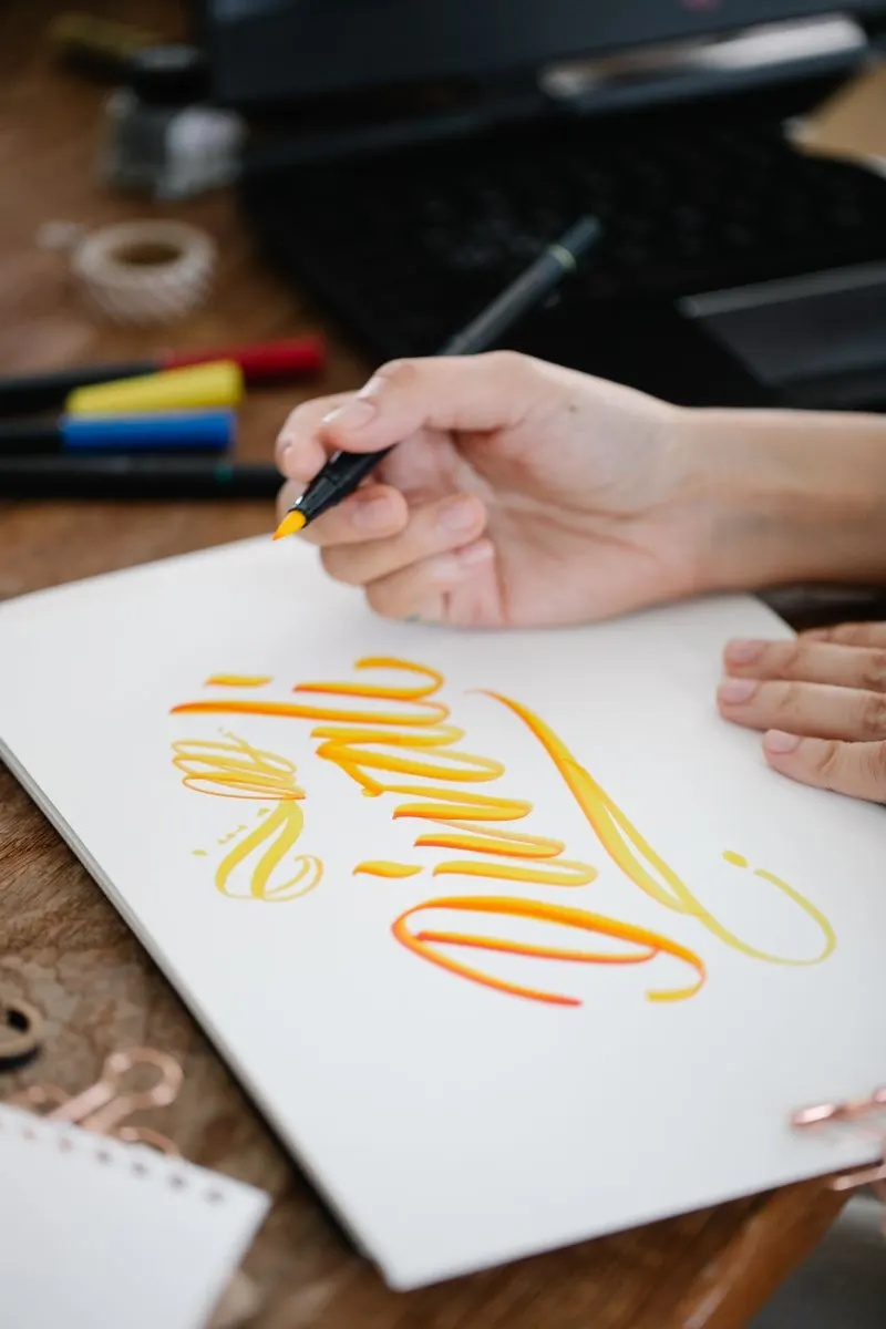 Colourful calligraphy being written with ink pens