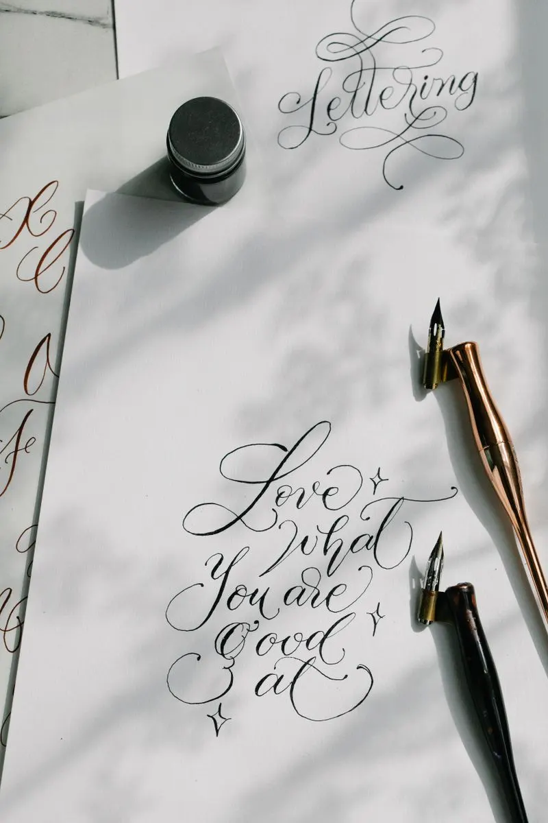 Calligraphy tools and handwritten text on paper