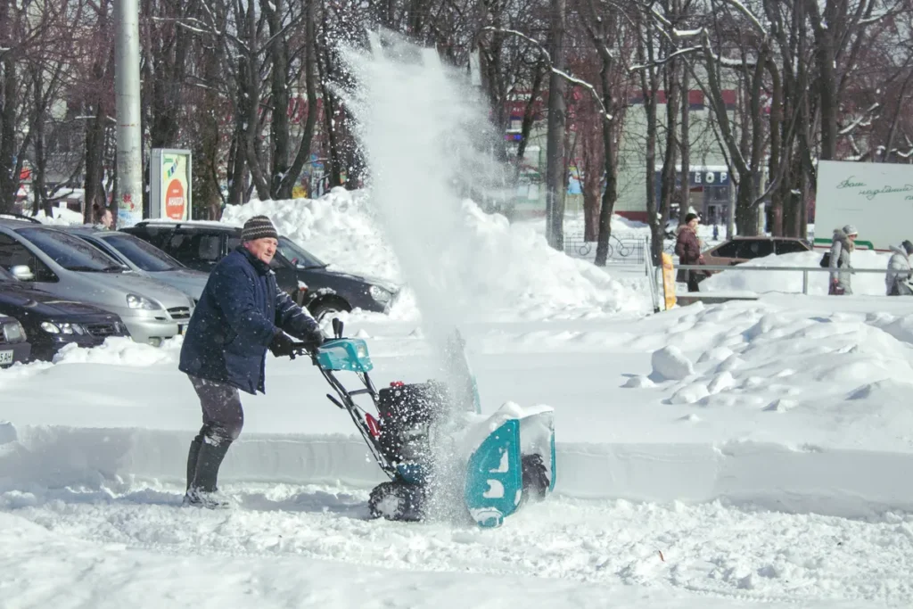 Crew member operating a snow blower
