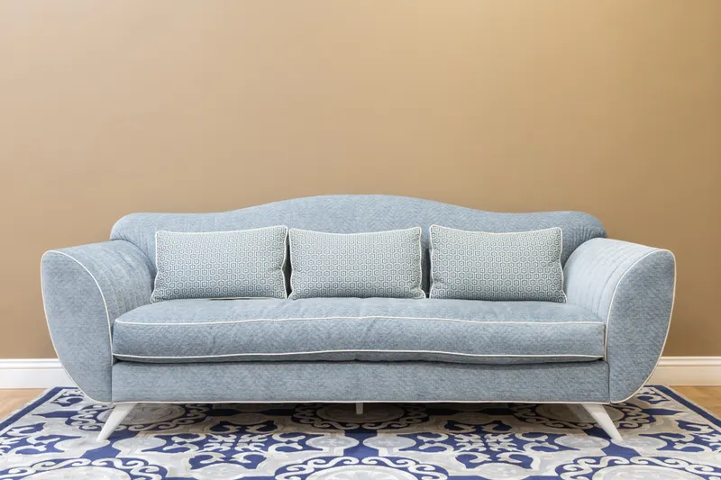 Blue sofa with cushions on a patterned rug